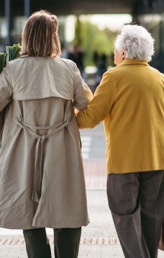Kvinna hjälper äldre kvinna att handla