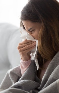 Kvinna i soffa med influensa
