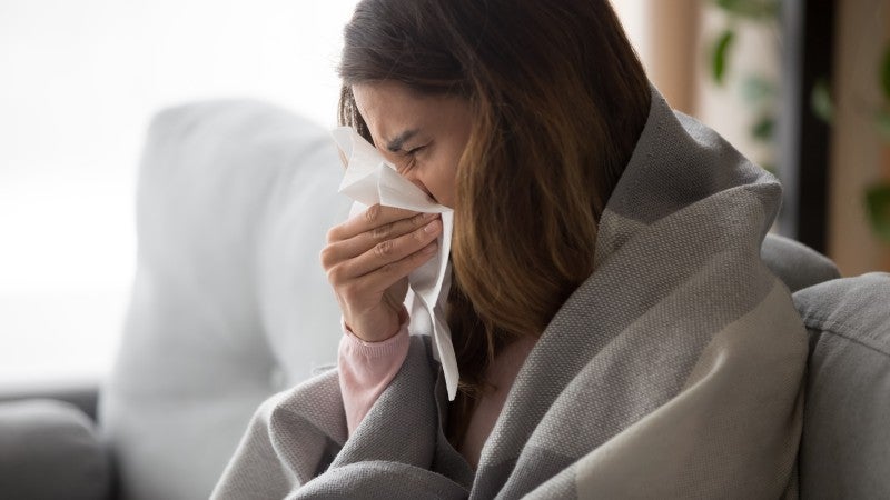 Kvinna i soffa med influensa