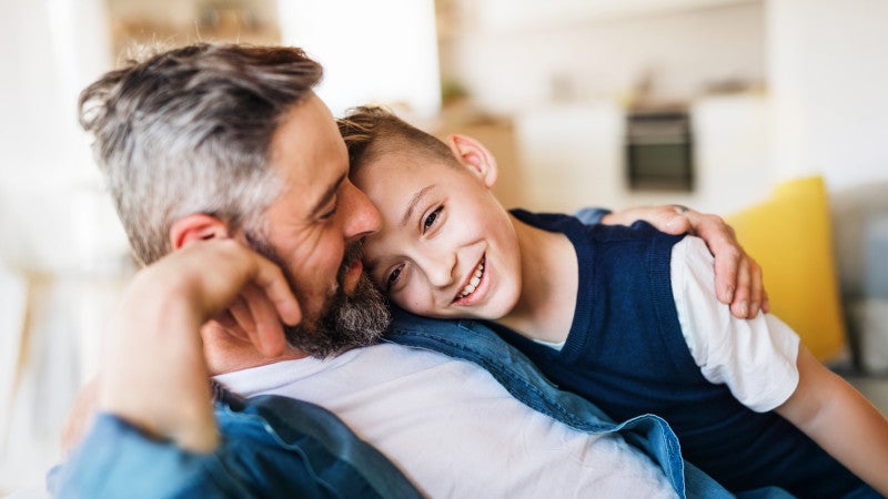 Far och son sitter tillsammans i en soffa.